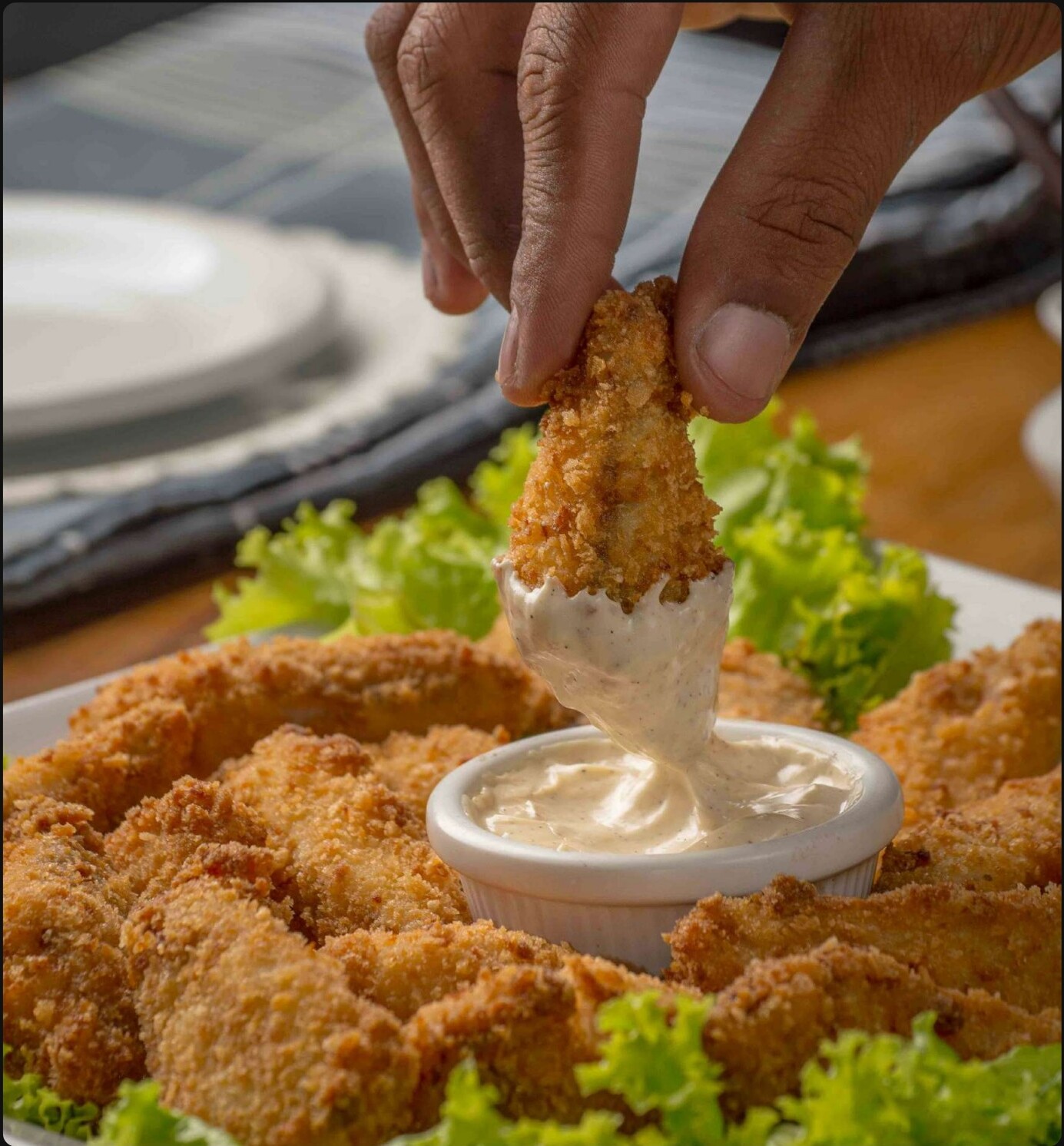 Hand dipping a tender into Messy Ranch